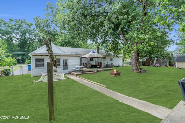 view of front facade featuring a wooden deck, an outdoor fire pit, a gazebo, and a front yard