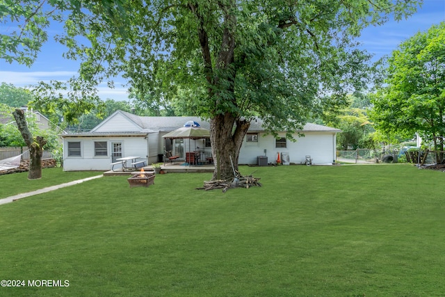 back of property featuring a fire pit, a gazebo, central AC, and a yard