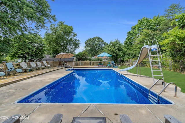 view of pool with a yard and a water slide