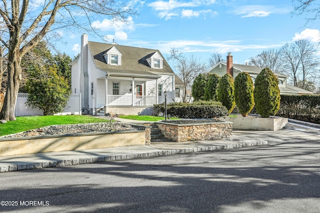 cape cod home featuring a porch