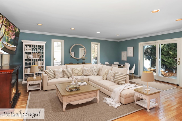 living room with ornamental molding and light hardwood / wood-style floors