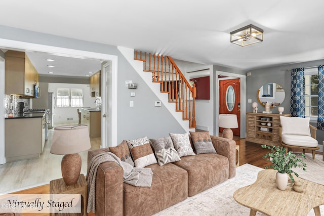 living room featuring sink and light hardwood / wood-style flooring