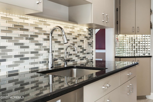 kitchen featuring sink, backsplash, and dark stone counters