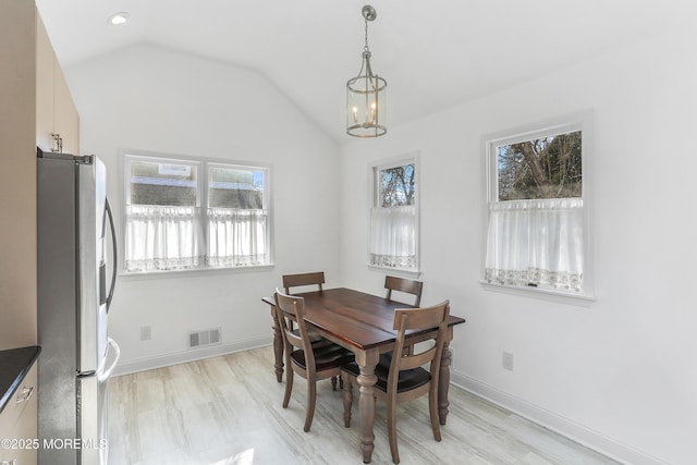 dining space featuring lofted ceiling and a chandelier