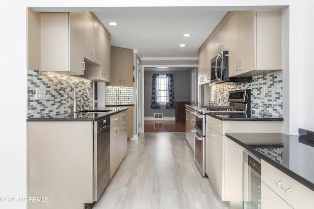 kitchen with wine cooler, appliances with stainless steel finishes, sink, and tasteful backsplash