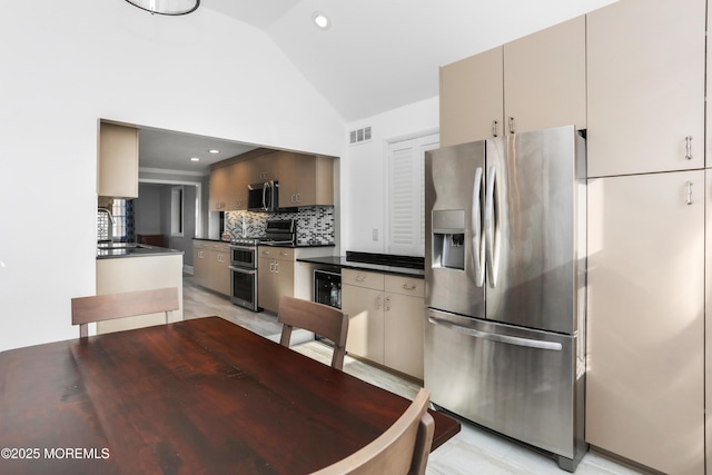 kitchen featuring vaulted ceiling, appliances with stainless steel finishes, sink, and decorative backsplash