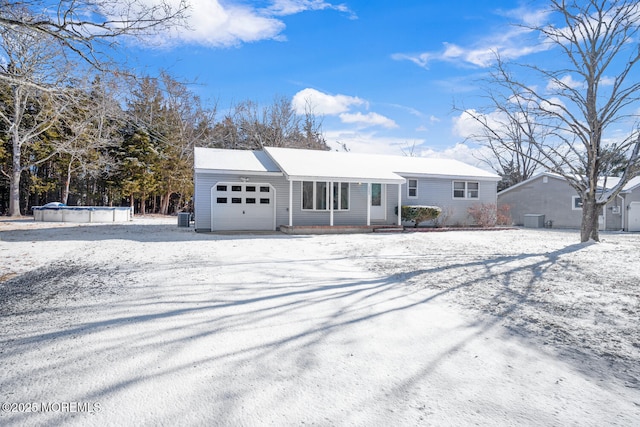 view of front of house featuring a covered pool and a garage