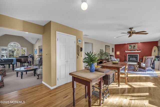 dining room featuring lofted ceiling, ceiling fan, and light wood-type flooring