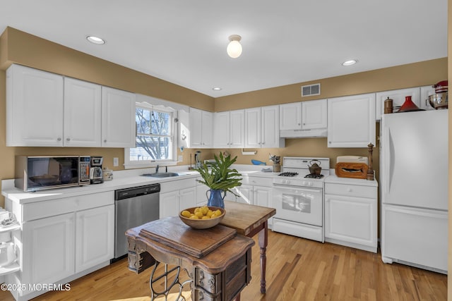 kitchen with white cabinetry, sink, white appliances, and light wood-type flooring