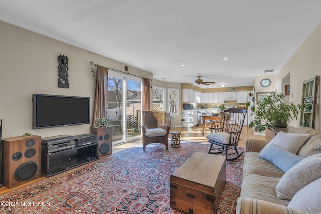 living room featuring light hardwood / wood-style flooring and ceiling fan