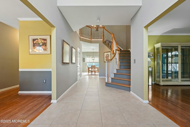 foyer entrance with light wood-type flooring and an inviting chandelier