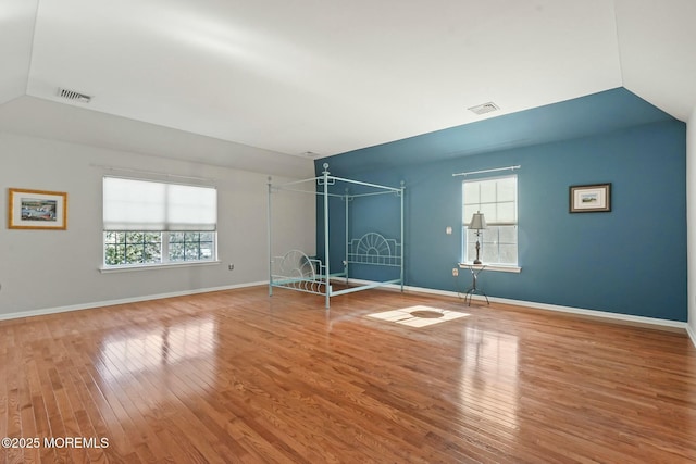 interior space with hardwood / wood-style flooring and vaulted ceiling