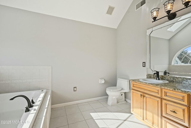 bathroom featuring tiled tub, tile patterned flooring, lofted ceiling with skylight, vanity, and toilet