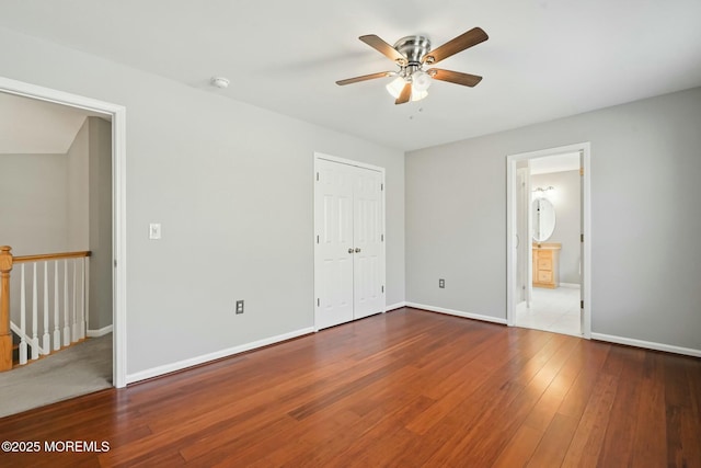 unfurnished bedroom featuring hardwood / wood-style flooring, a closet, and ceiling fan