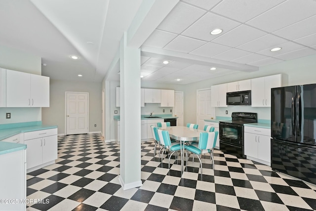 kitchen with white cabinetry, sink, and black appliances