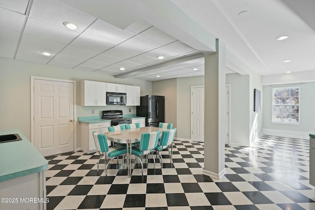 interior space featuring white cabinetry, sink, a paneled ceiling, and black appliances