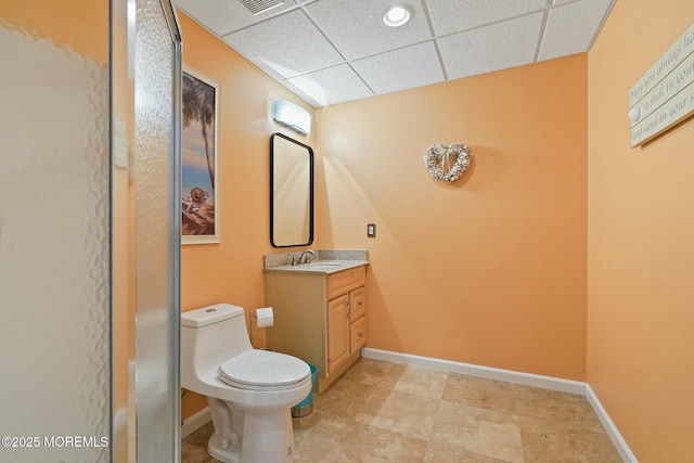 bathroom with a paneled ceiling, vanity, and toilet