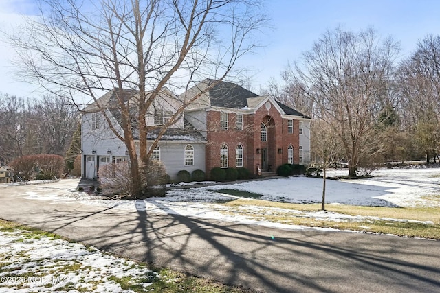 snow covered property with a garage