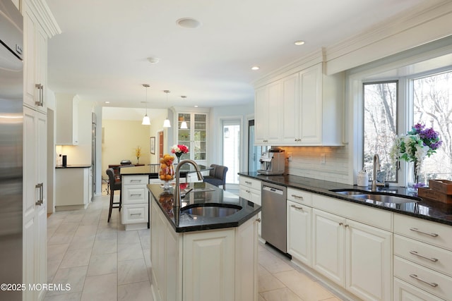 kitchen featuring an island with sink, dishwasher, white cabinetry, and a sink