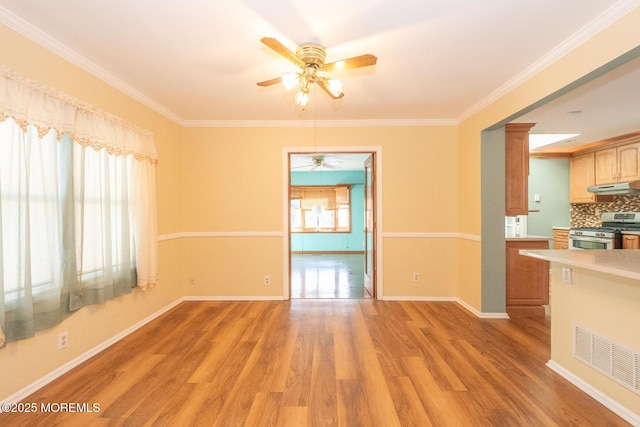 unfurnished living room with crown molding, plenty of natural light, ceiling fan, and light wood-type flooring