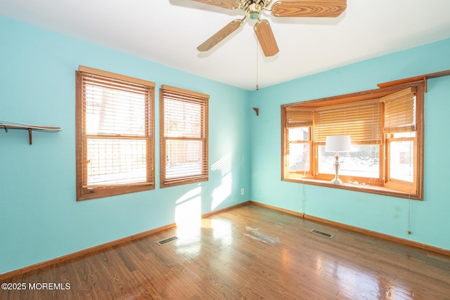 spare room featuring plenty of natural light, hardwood / wood-style floors, and ceiling fan