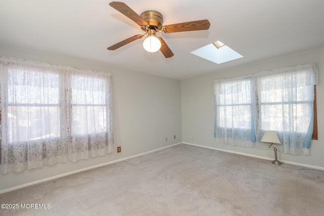 unfurnished room with light carpet, a skylight, and plenty of natural light