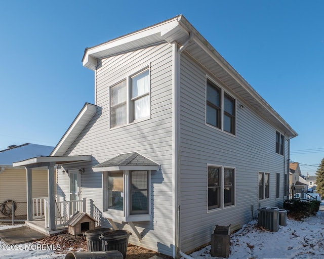 snow covered back of property with central AC unit