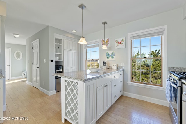 kitchen featuring white cabinetry, hanging light fixtures, stainless steel gas range, and kitchen peninsula