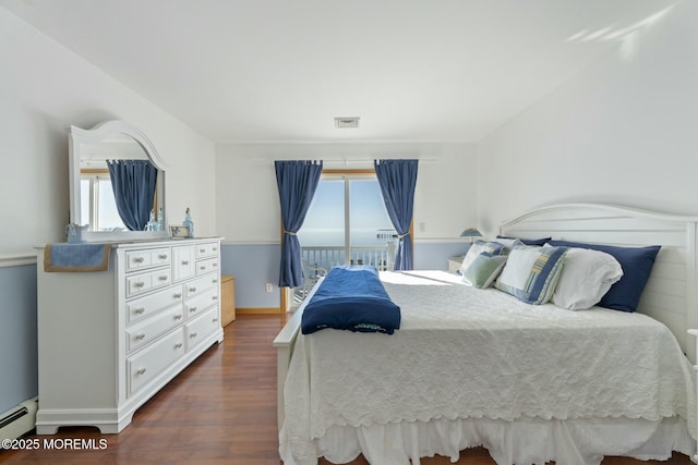 bedroom with dark wood-type flooring and a baseboard radiator