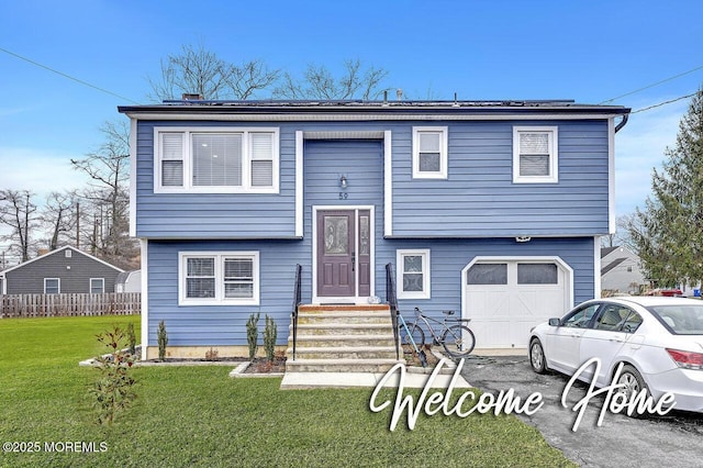 split foyer home with a garage and a front lawn