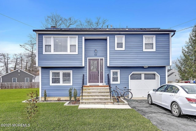 bi-level home with a front yard and a garage