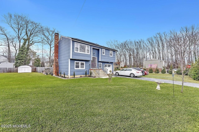 split foyer home with a front yard and a storage shed