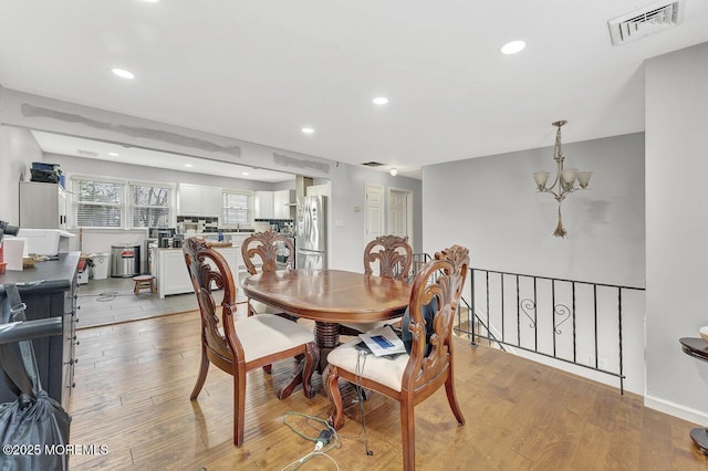 dining room featuring light wood-type flooring and a chandelier