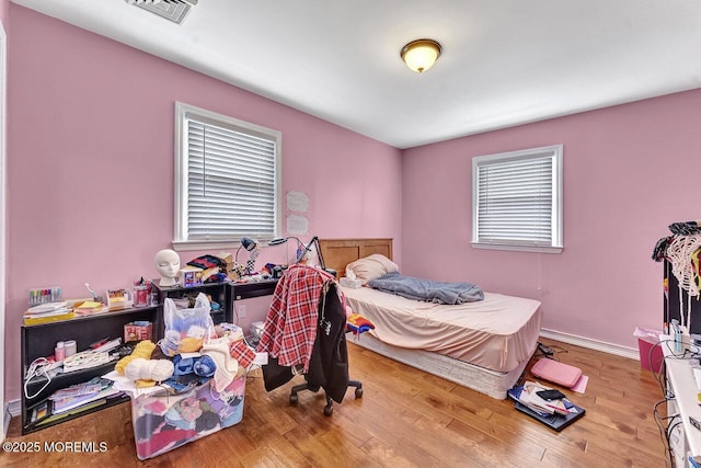 bedroom with light wood-type flooring and multiple windows