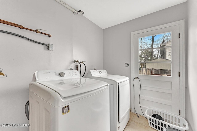 clothes washing area featuring light tile patterned floors and washing machine and clothes dryer