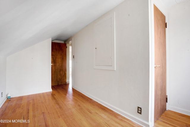 additional living space with light hardwood / wood-style floors and lofted ceiling