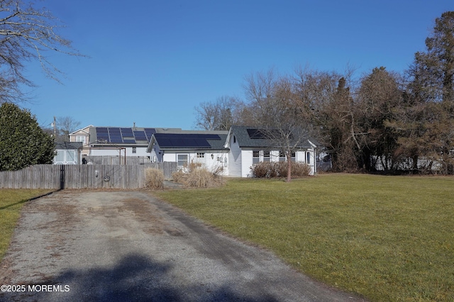 exterior space featuring a front lawn and solar panels