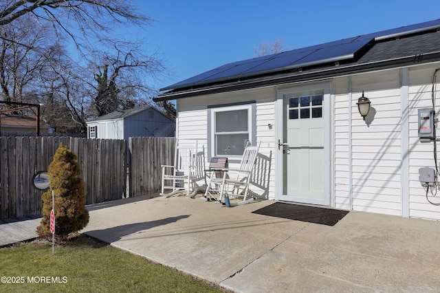 entrance to property featuring solar panels and a patio area