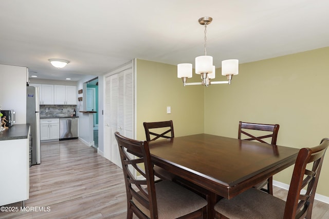 dining area featuring light hardwood / wood-style floors and a chandelier