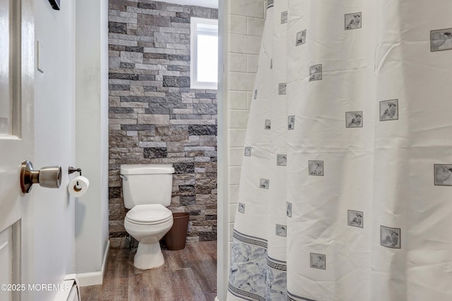 bathroom with hardwood / wood-style flooring, toilet, and a shower with curtain