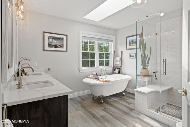 66 Banyan Blvd, Holmdel, NJ 07733 - full bathroom featuring a skylight, a stall shower, a freestanding tub, double vanity, and wood finished floors