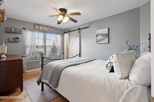 66 Banyan Blvd, Holmdel, NJ 07733 - bedroom featuring a barn door, wood finished floors, and ceiling fan