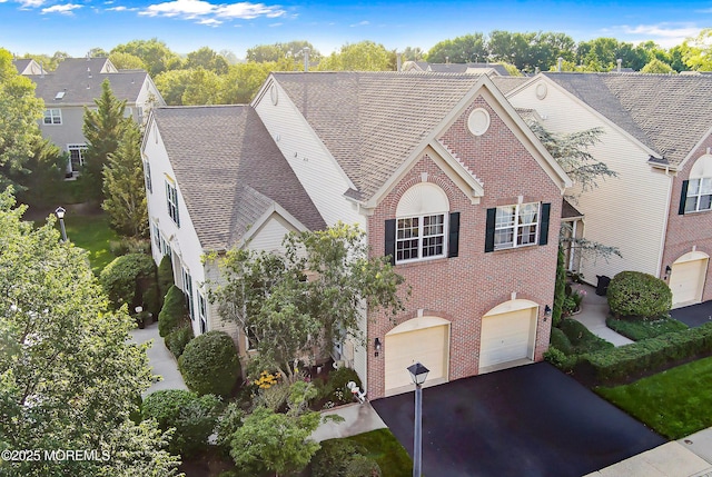 66 Banyan Blvd, Holmdel, NJ 07733 - view of front facade with driveway, brick siding, an attached garage, and a shingled roof