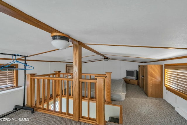 hall featuring vaulted ceiling and carpet flooring