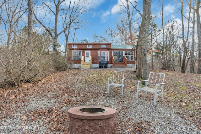 rear view of house with an outdoor fire pit