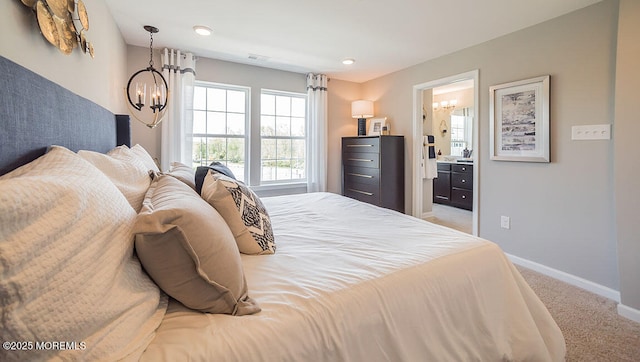 bedroom with light carpet, connected bathroom, and a chandelier