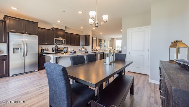 dining area featuring an inviting chandelier and light wood-type flooring