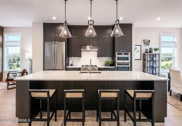 kitchen featuring pendant lighting, a kitchen island with sink, and appliances with stainless steel finishes