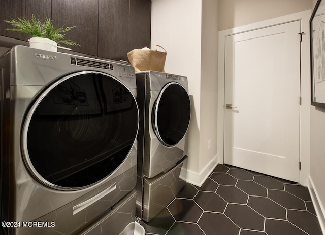 laundry room featuring dark tile patterned flooring and washer and dryer