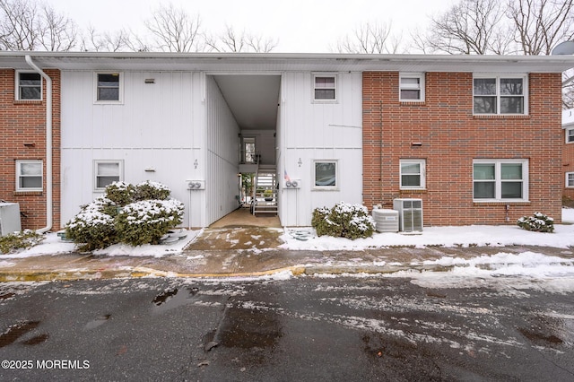 snow covered property featuring central air condition unit